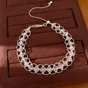 Vue détaillée d'un bracelet tissé en perles de verre roses sur un plateau en velours