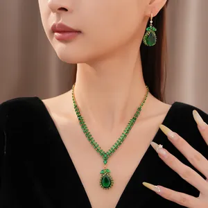 Detailansicht eines eleganten Vintage-Schmucksets mit smaragdgrünen Tropfenanhängern