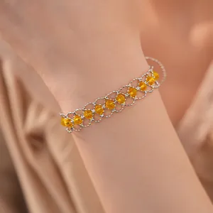 Gros plan bracelet en maille de perles de verre avec pierres jaunes et boucle réglable