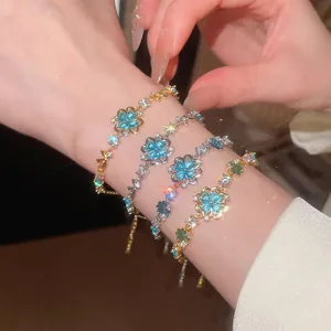 Detailed macro view of sparkling ice blue zircon flower bracelets on a wrist.