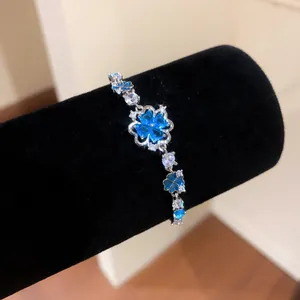 Detailed macro shot of an elegant blue zircon flower bracelet on a black velvet display