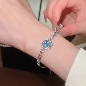 Elegant silver bracelet featuring a blue zircon flower and sparkling accents on wrist