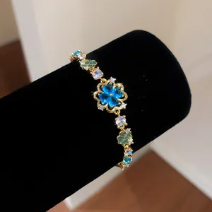 Detailed close-up shot of ice blue zircon flower gold bracelet on black velvet display