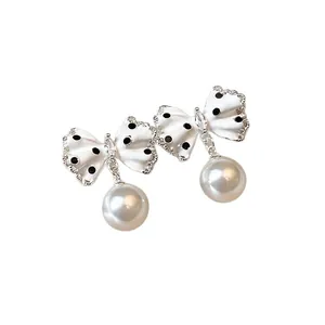 Eleganti orecchini a fiocco a pois bianchi con perle pendenti e dettagli in cristallo