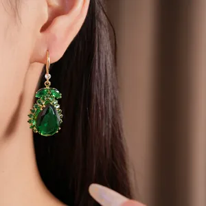 Nahaufnahme von eleganten grünen Vintage-Zirkonia-Ohrring-Tropfen an einem Model.