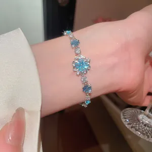 Close-up view of elegant sea blue zircon flower bracelet worn on a female wrist