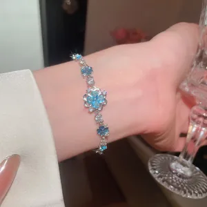 Exquisite detail of icy sea blue sparkling zircon flower bracelet worn with elegant jewelry style