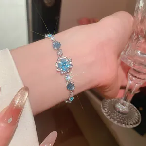 Detailed macro view of a light blue flower zircon bracelet sparkling on a lady's wrist.