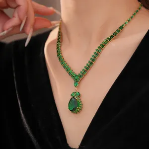 Nahaufnahme einer Vintage Halskette mit smaragdgrünem Tropfenanhänger an einem Model