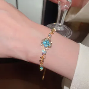 Detailed view of a sparkling sea blue zircon flower bracelet on a wrist.