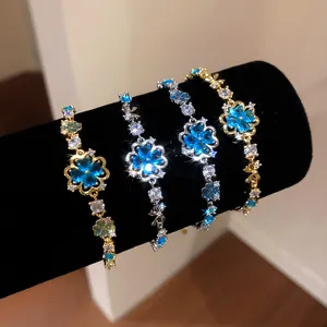 Detailed view of four elegant blue zircon flower bracelets on black velvet display