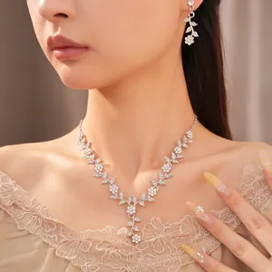 Close-up of sparkly leaf and flower necklace and earrings set on an elegant model