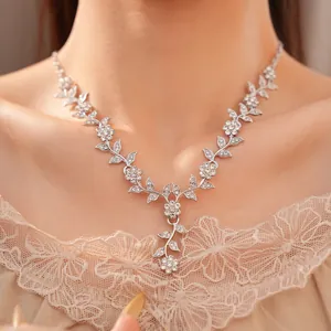 Close-up of elegant rhinestone flower and leaf necklace on female model's graceful neckline