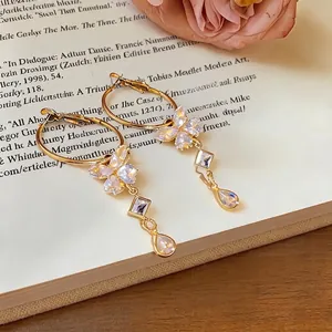 Elegante goldene Schmetterlings-Creolen mit funkelnden Zirkon-Quasten und Tropfenanhängern.