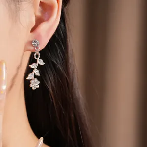 Close-up of elegant floral and leaf dangle earrings with sparkling rhinestone details