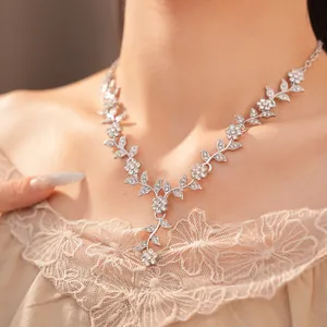 Detailed close-up showing a sparkling rhinestone floral and leaf vine necklace on a neck