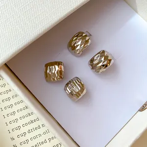 Gros plan détaillé de boucles d'oreilles carrées argentées avec texture motif chocolat élégante.