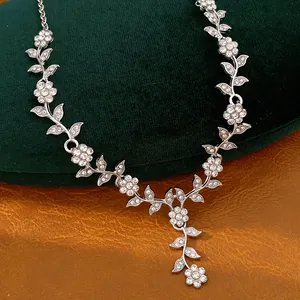 Detailed macro view of elegant silver leaf and flower vine necklace with crystals