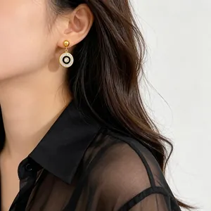 Close-up of elegant gold plated circle drop earrings with rhinestones on model