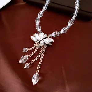 Close-up view of elegant floral crystal pendant necklace with dangling gold chains