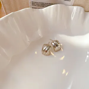 Gros plan de boucles d'oreilles carrées avec un motif facetté et scintillant