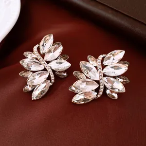 Elegant silver pin earrings with sparkling leaf-shaped crystals on brown satin