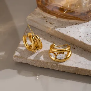 Gros plan sur des boucles d'oreilles en C plaqué or avec des zircons blancs brillants