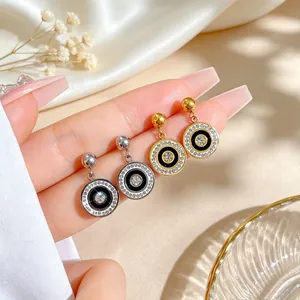 Close-up detail of elegant round titanium steel earrings with sparkling rhinestone inlay