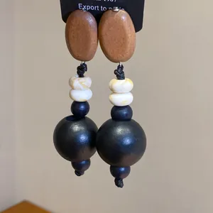 Detailaufnahme von handgefertigten Ohrringen aus Holz und Acrylperlen auf Karte