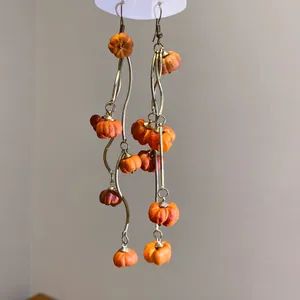 Detailansicht der originellen orangefarbenen Kürbis-Ohrhänger mit gebogenen Nadeln