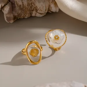 Detailansicht der 18 Karat vergoldeten Edelstahlringe mit Muschel- und Blumenmotiv.