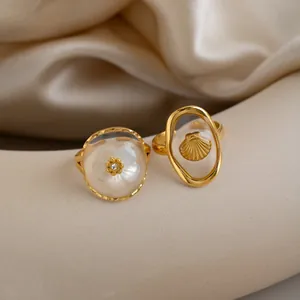 Nahaufnahme von goldenen Edelstahlringen mit Muschel- und Blumenmotiven für Damen