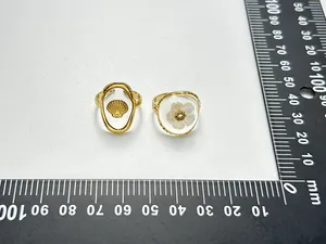 Detailansicht goldener Edelstahlringe mit Muschel- und Blumenmotiv mit Messskala