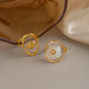 Nahaufnahme von 18K vergoldeten Edelstahlringen mit Muschel- und Blumenmotiven