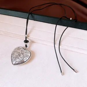 Vintage heart locket necklace with floral engraving and black leather cord