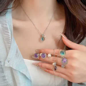 Vue détaillée d'un ensemble collier et bague en résine zircon transparente sur un mannequin.