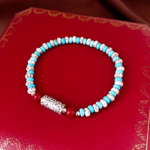 Detail of a beaded bracelet featuring white bodhi seeds and sky blue stone beads.