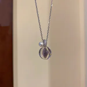 Gros plan du pendentif boule en résine avec bélière en zircon et perle élégante