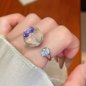 Gros plan détaillé d'une bague en résine transparente avec pierre violette et zircon
