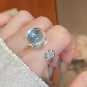 Gros plan d'une bague ouverte en résine glacée transparente et zircon au design moderne niche