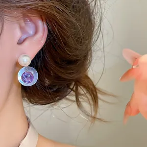Gros plan de boucles d'oreilles élégantes en résine et zircon violet avec perle