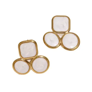 Geometric gold-plated stainless steel stud earrings with white enamel swirl texture