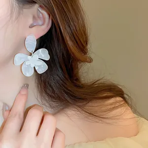Detaillierte Nahaufnahme von eleganten Harzblumenohrringen mit Marmormuster am Modell