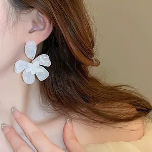 Nahaufnahme von eleganten weißen Marmor-Resin-Blütenohrringen mit feinen Details