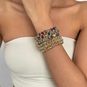 Detailansicht der vintage Glasperlen- und Goldketten-Armbänder an einem Handgelenk.