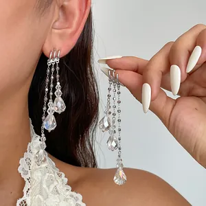 Détail de boucles d'oreilles argentées à pampilles avec gouttes de verre irisées