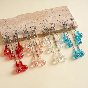 Élégantes boucles d'oreilles pendantes à pompons avec perles de verre colorées.