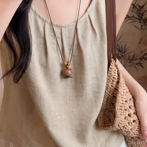 Handcrafted wooden bear pendant necklace with brown leather cord and beads in ethnic style