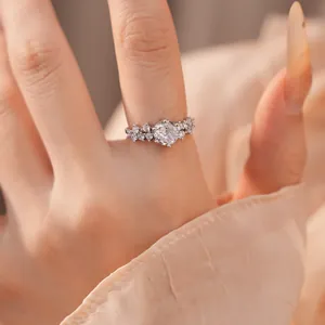 Nahaufnahme eines funkelnden runden Zirkonia-Rings an einem Finger mit eleganter Maniküre