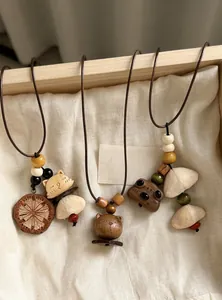 Detail showing three handmade wooden animal charms on ethnic beaded cord necklaces for women